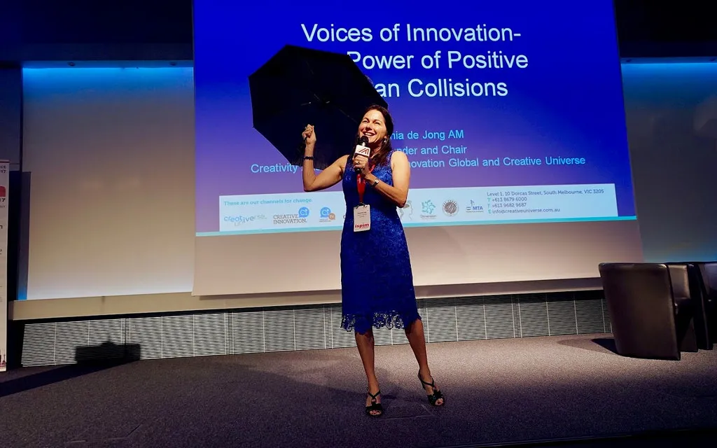 Tania holding an umbrella as part of a keynote presentation